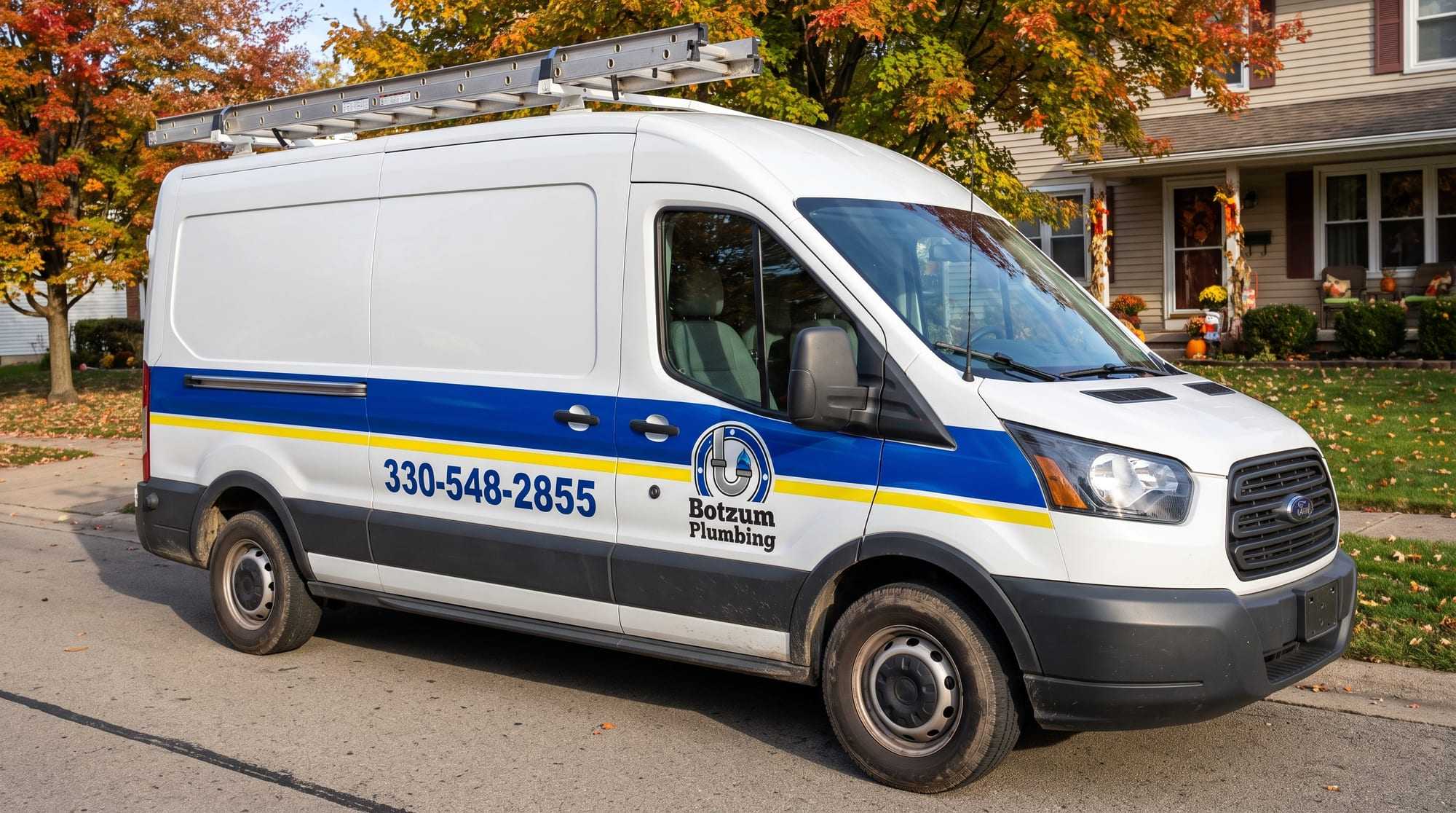White Botzum Plumbing van with a royal blue band and yellow stripe, the logo on the front door and 330-548-2855 on the side, parked on an autumn street